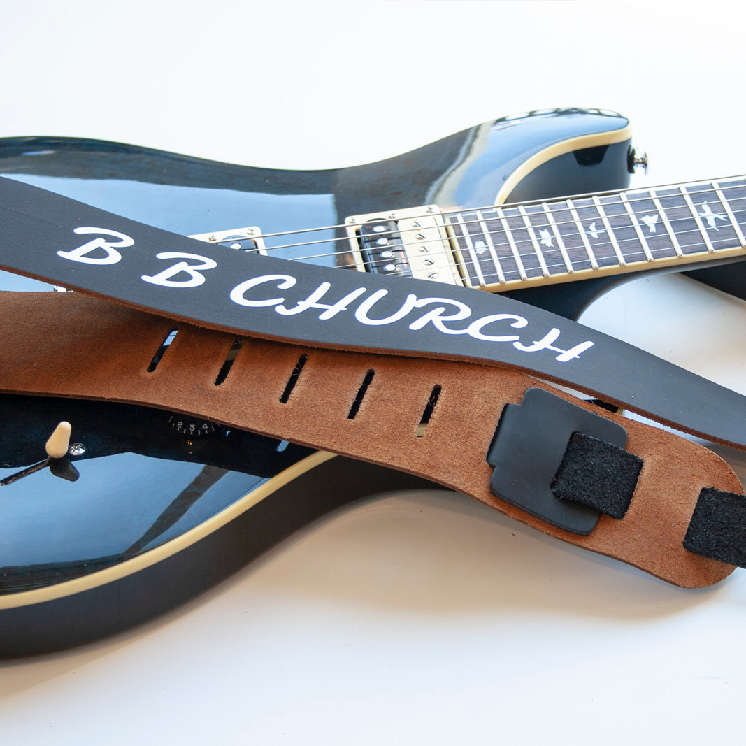 Leather guitar strap on a guitar. 