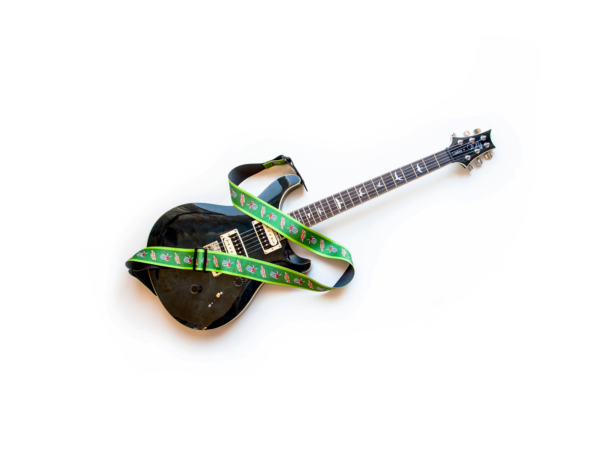 Green graphic polyester guitar strap on a guitar. 