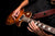 Guitar player shredding on the guitar, wearing a cool guitar strap.