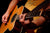 Man playing a acoustic guitar with a guitar strap.